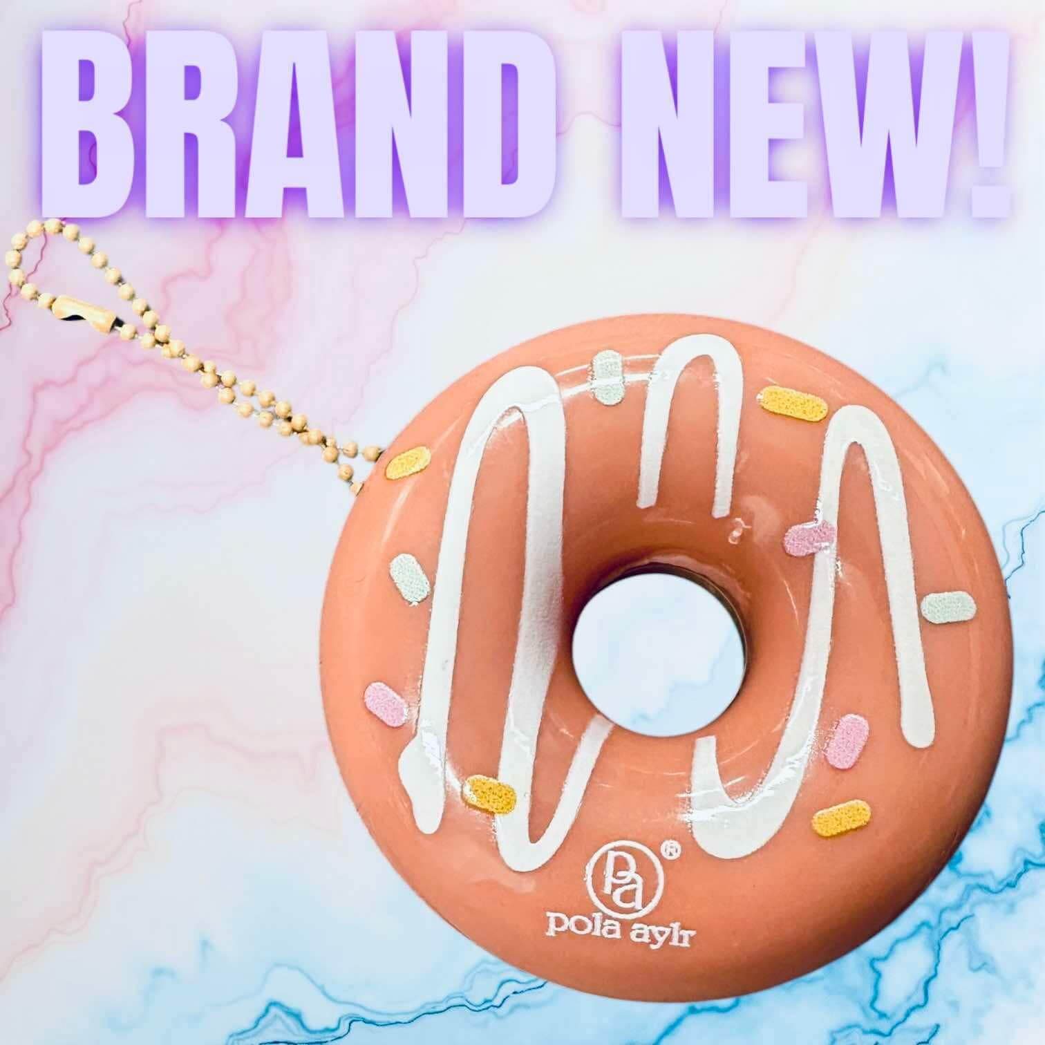 Donut Worry Lip Balm by Pola aylr, key chain attached, in pink with white icing and colorful sprinkles.