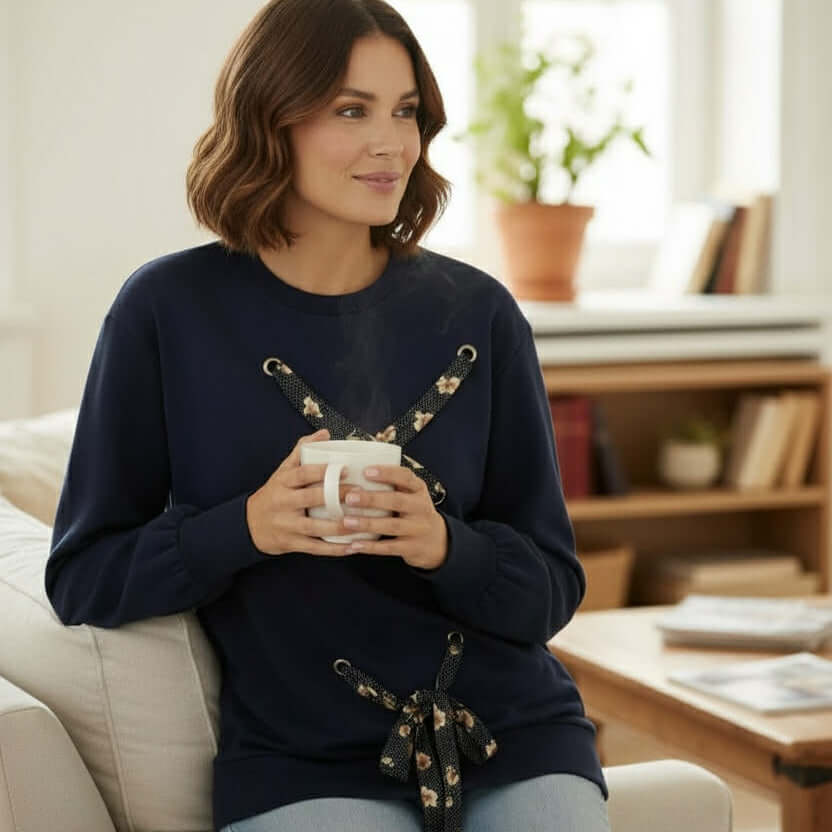 Model wearing SOFT TIES Crewneck Pullover By Skies Are Blue, holding coffee in a cozy indoor setting.