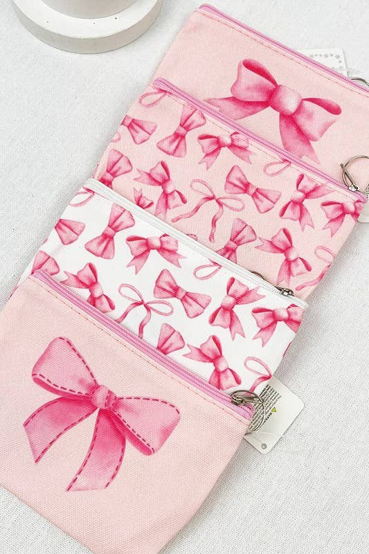 Stylish BOW ME OVER COSMETICS BAG featuring pink bows, perfect for organizing makeup on-the-go.