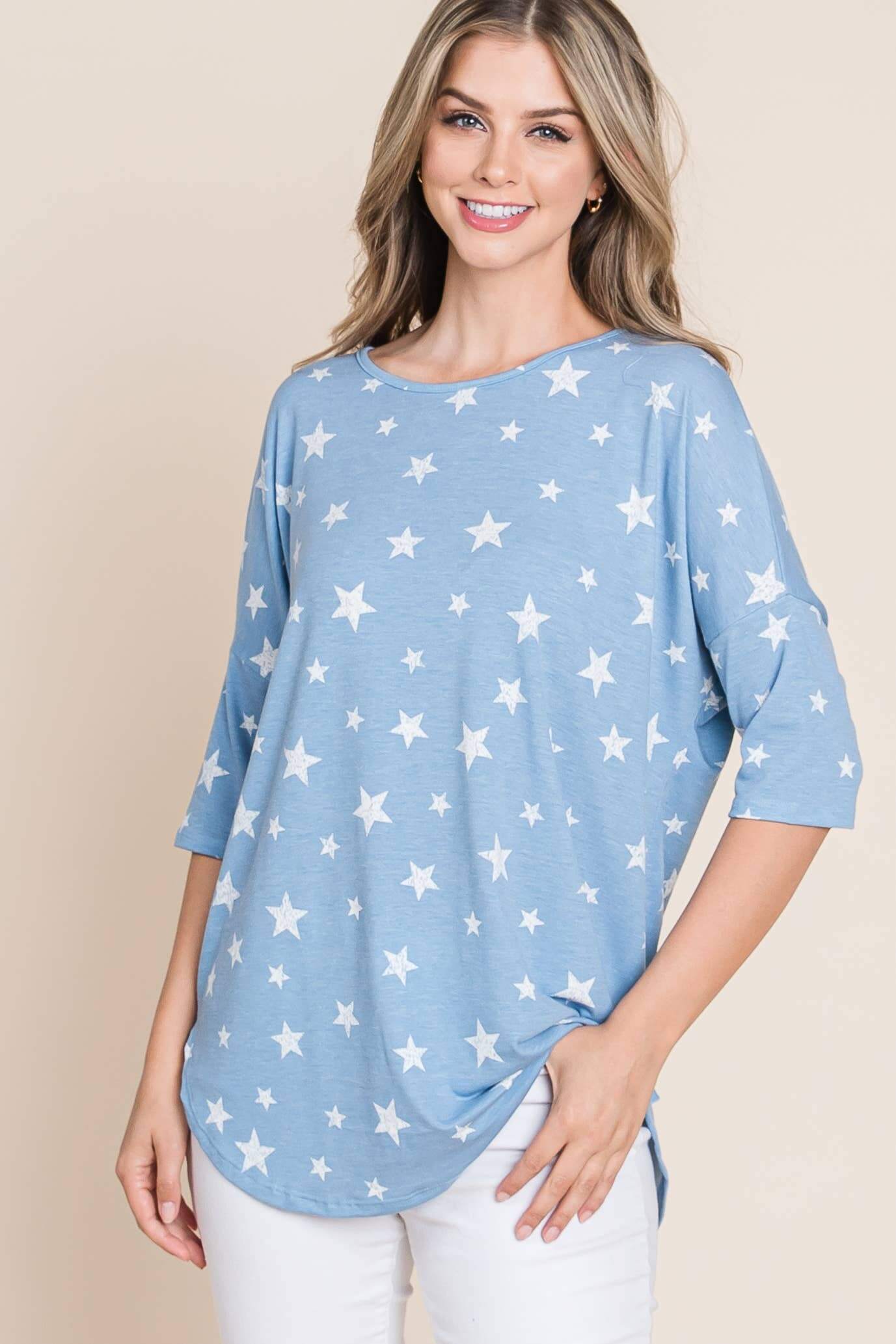 Woman wearing the Sparks Fly Top, a blue tunic with a soft white star print, perfect for casual outings.