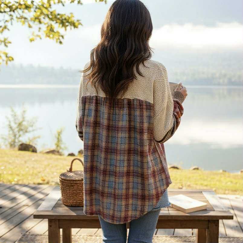 Back view of a woman wearing the CAMPFIRE REMIX Top (cream) with plaid patchwork sleeves by a lake.