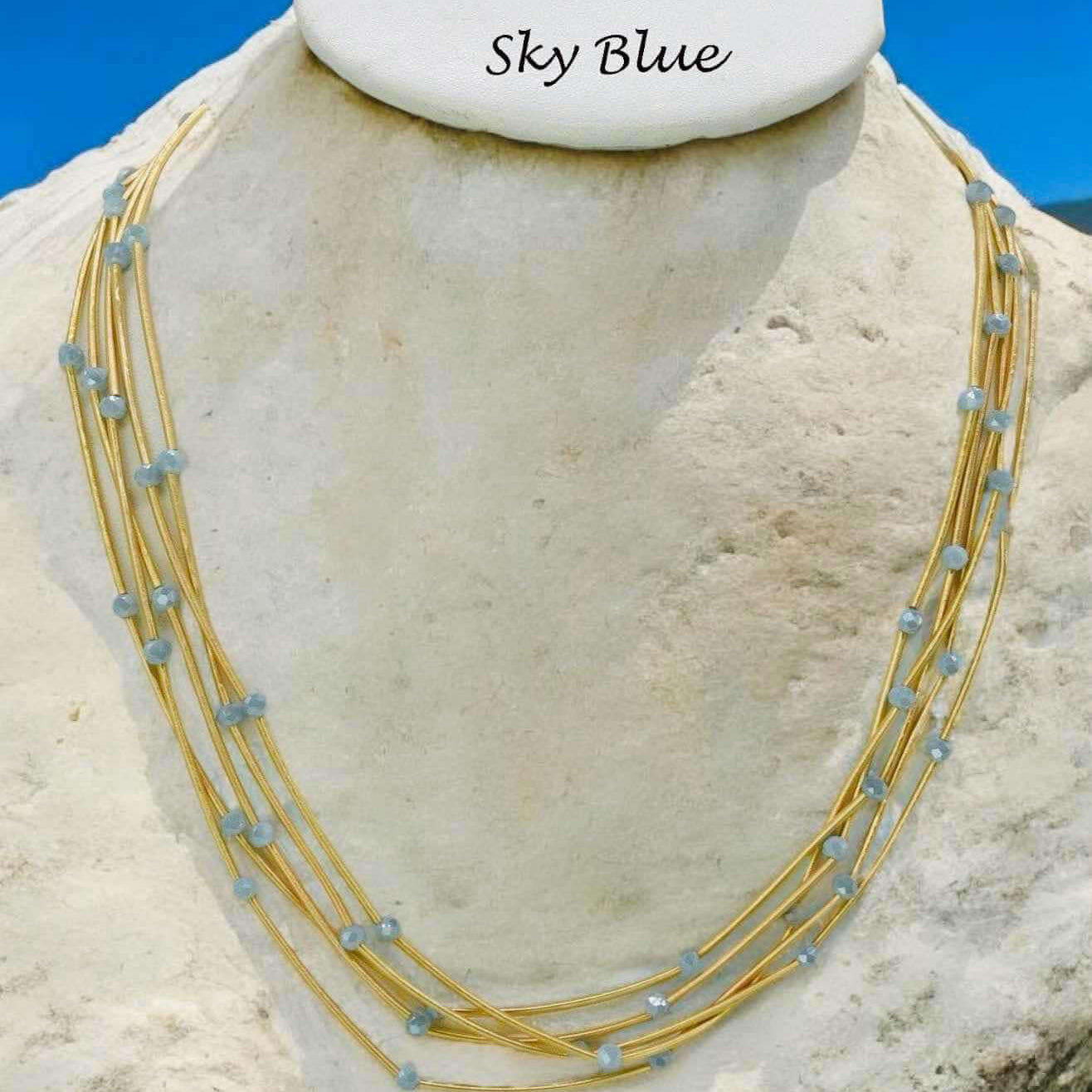 Sky blue Pretty Strands Necklace by Nine with gold tone multi strands and glass beads, 22 inches adjustable.
