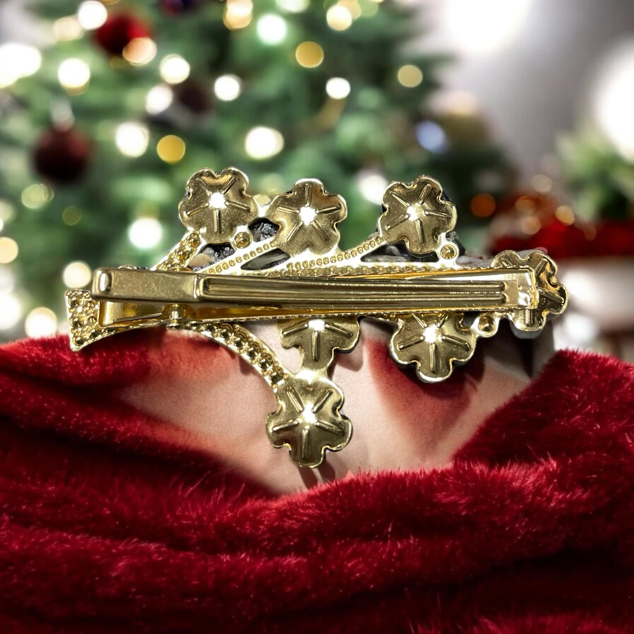 Gold rhinestone flower hair clip on red velvet fabric, perfect for holiday styling.