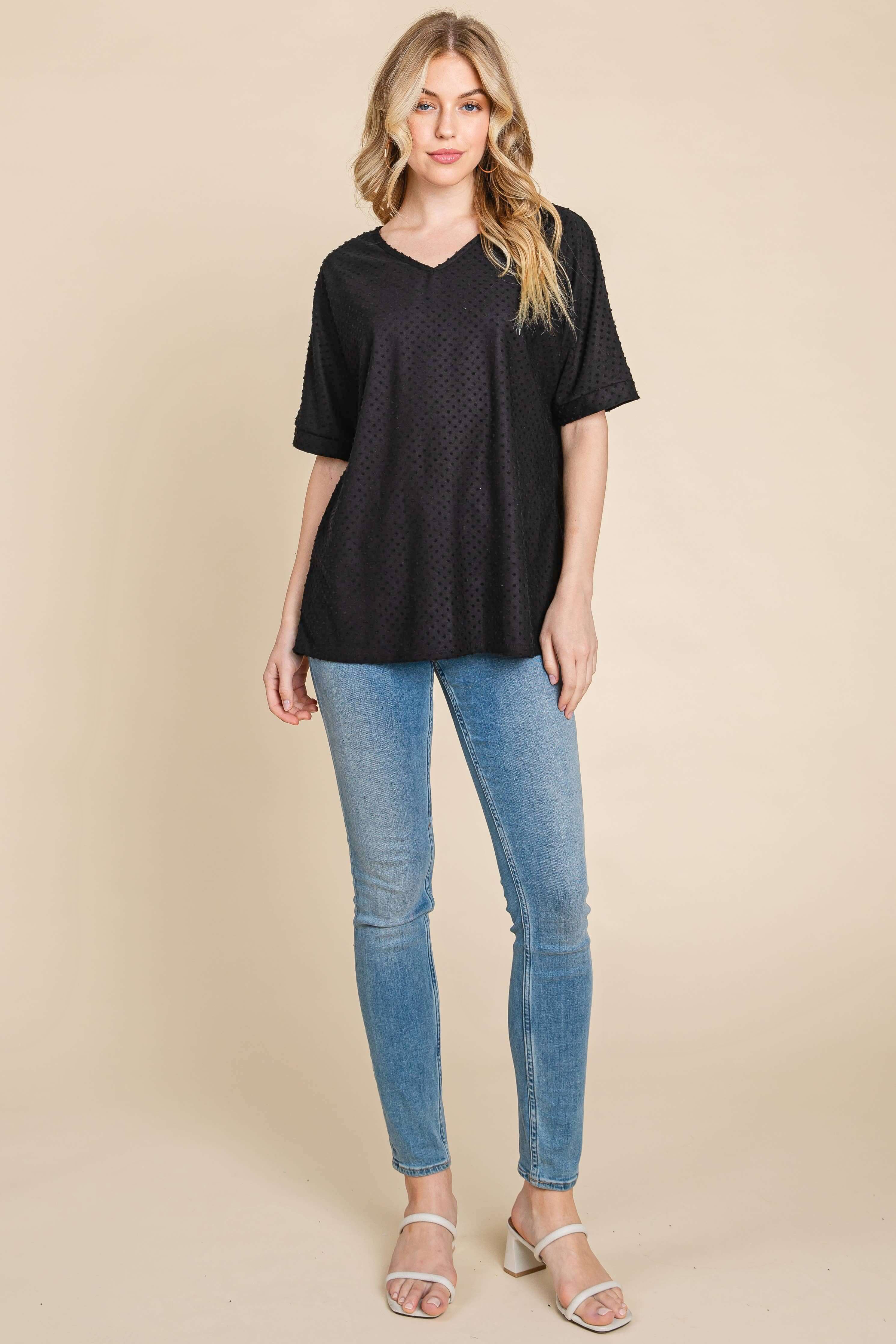 Model wearing the Midnight Moments Top in black with jeans, showcasing its relaxed fit and tufted Swiss dot texture.