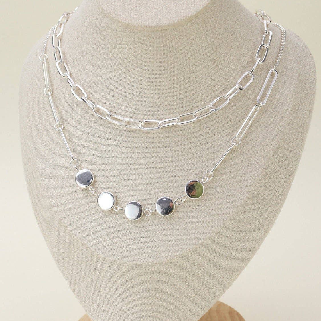 Two layer silver chain necklace set displayed on a jewelry bust, showcasing its elegant design and versatility.