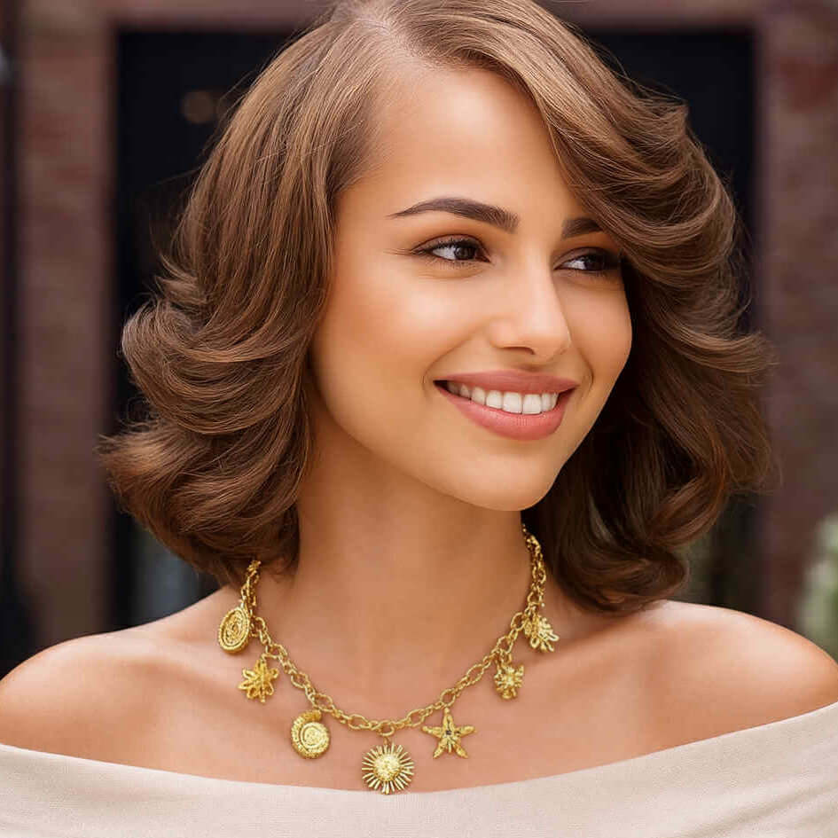 WALKIN ON SUNSHINE CHARM NECKLACE worn by a smiling woman, featuring sunshine and beach-themed gold charms.