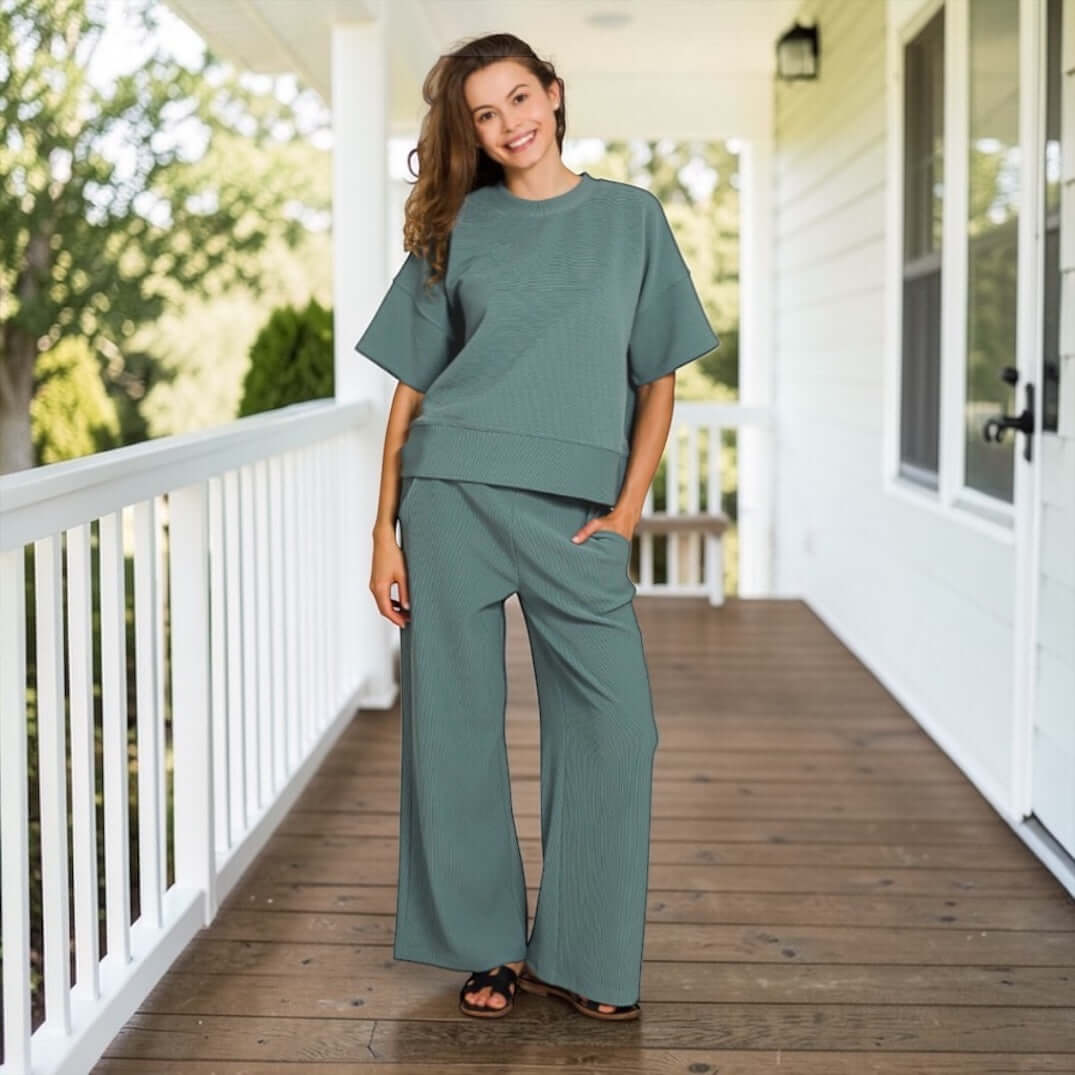 Model wearing QUIET MOMENTS PANTS SET (ash jade) on porch, showcasing stylish and comfortable outfit.
