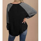 Finding Time (soft black) top showcasing contrasting striped raglan long sleeves and a stylish design.
