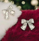 SILVER BOW Stud Earrings from Vivian-Lu on a plush background, showcasing elegant bow design and flawless texture.