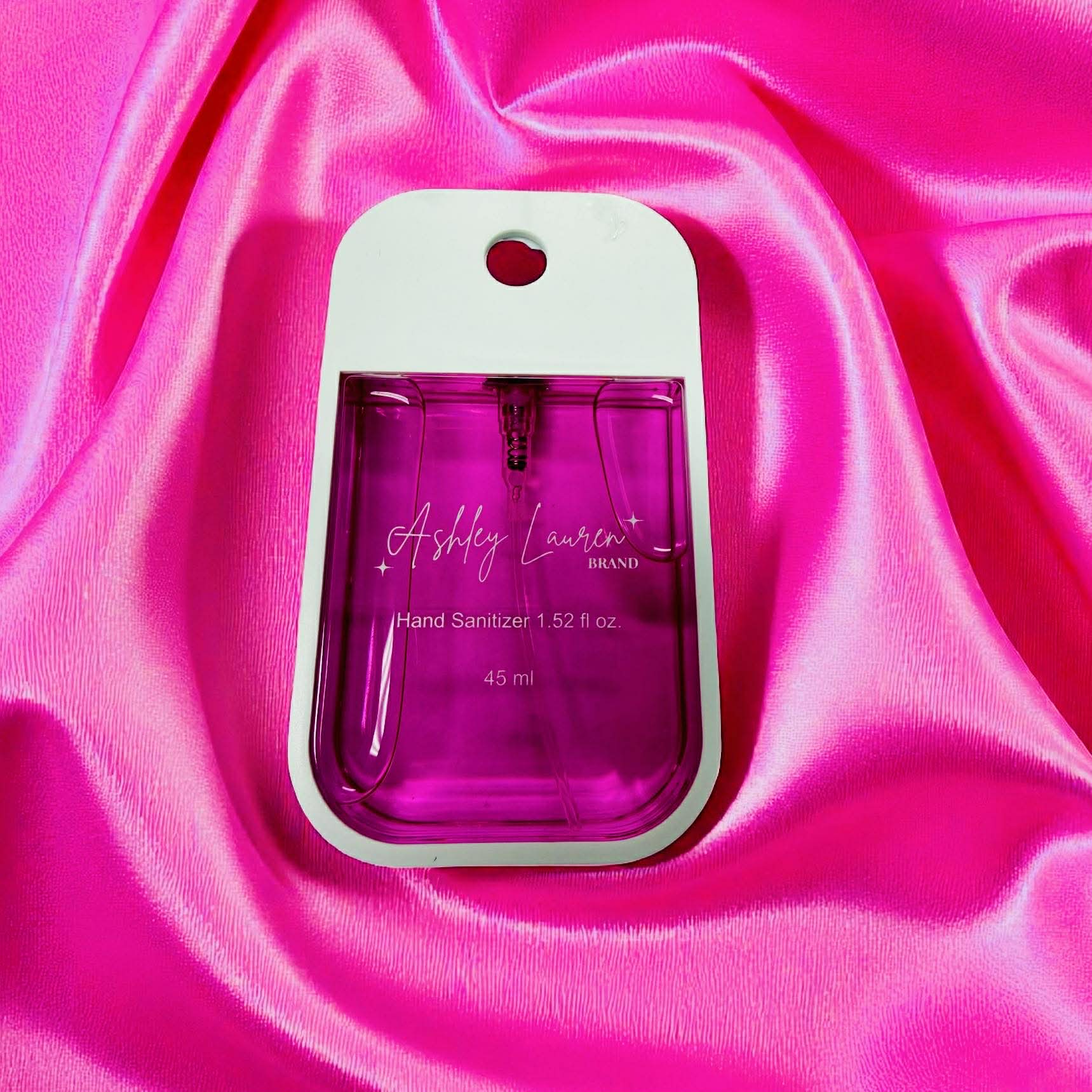 ASHLEY LAURA XL STRAWBERRY HAND SANITIZER in a vibrant bottle on soft pink satin fabric.