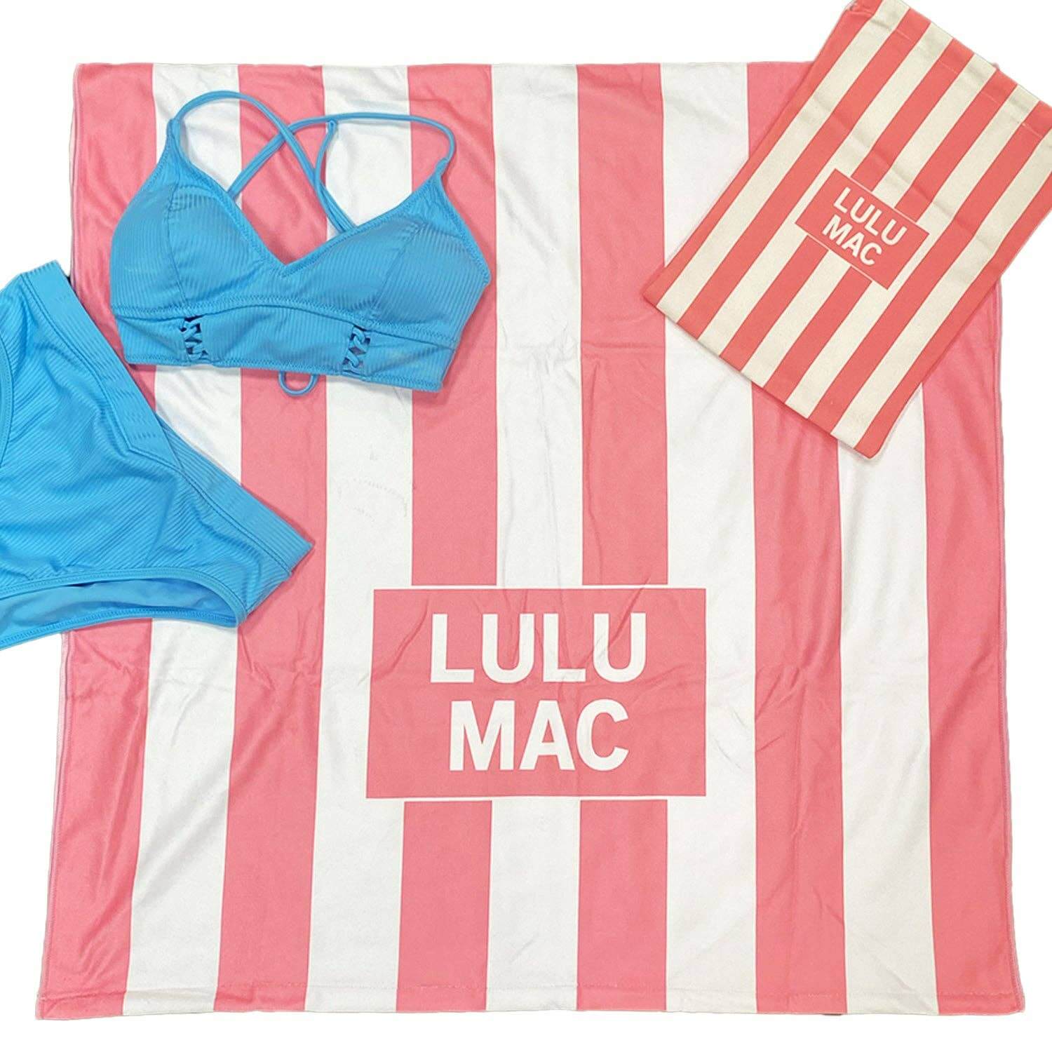 LULU MAC DARBY BEACH TOWEL (taffy pink) displayed with a blue bikini and burlap carrying case, perfect for summer.