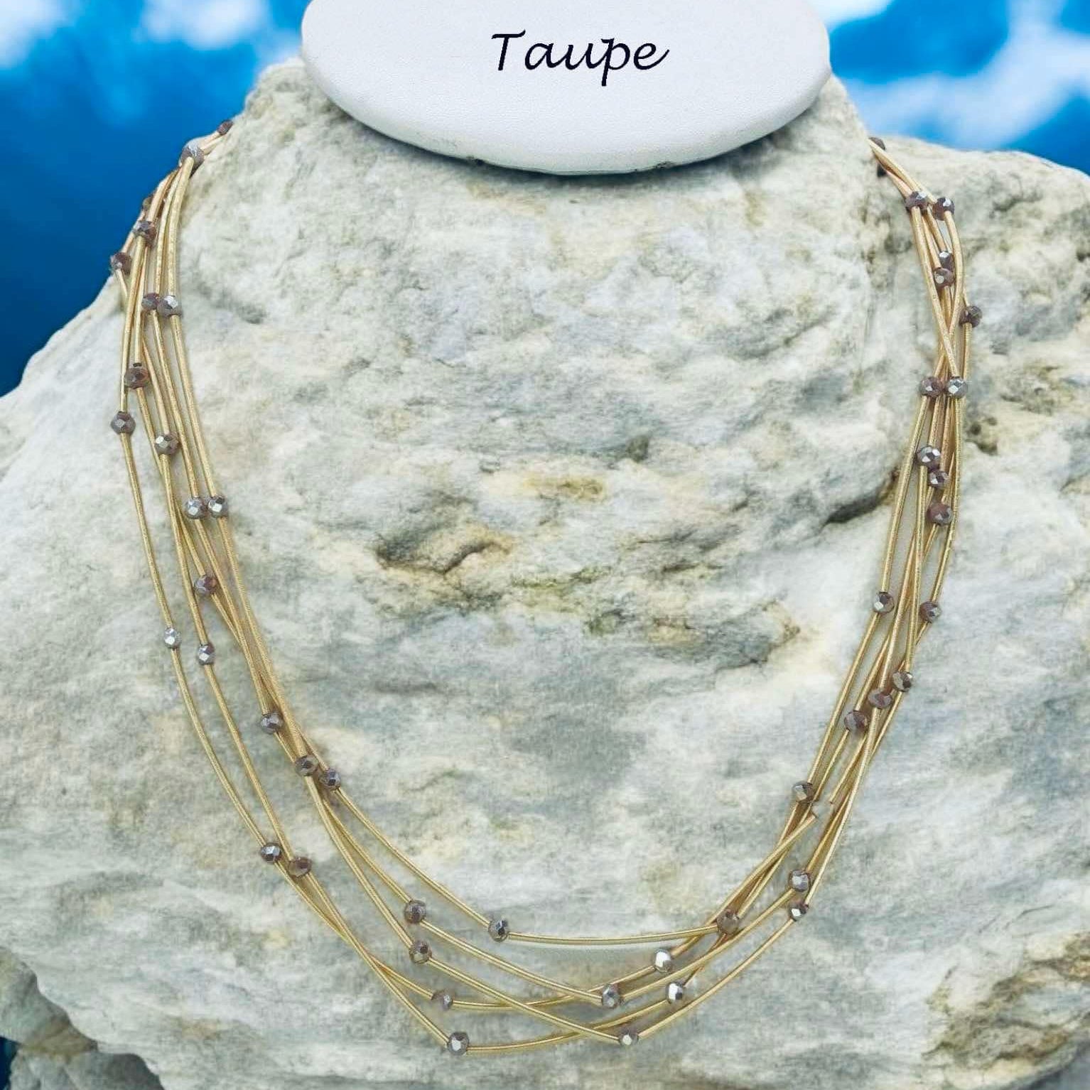 Pretty Strands Necklace in taupe, featuring glass beads on a gold tone multi strand design, 22 inches long.