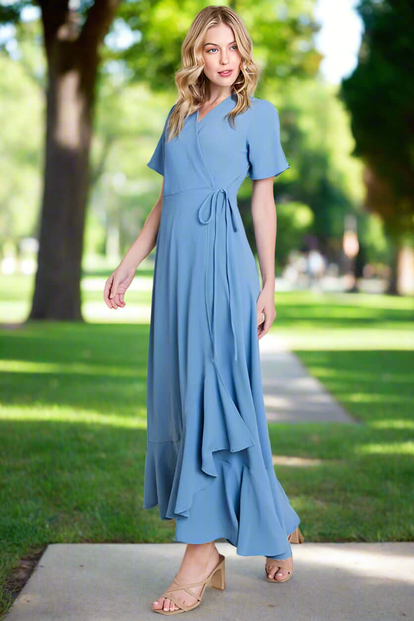 Model wearing Breezy Blue Maxi Dress by BomBom, high/low hem, perfect for any occasion in a park setting.