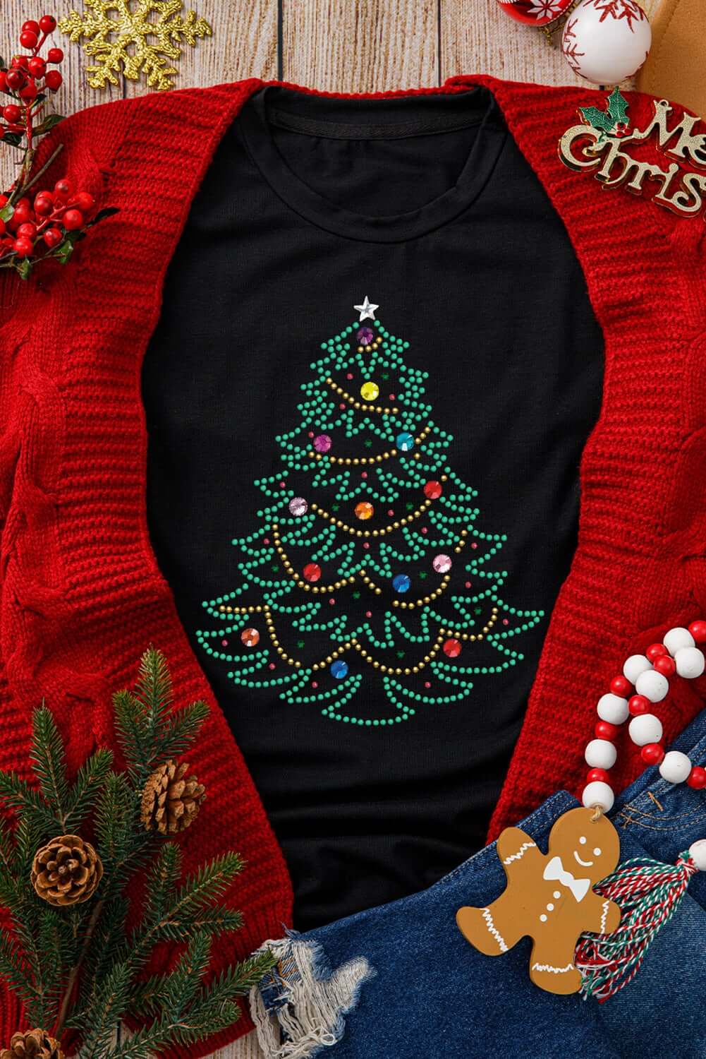 Black t-shirt with studded Christmas tree design, styled with red cardigan and festive accessories.