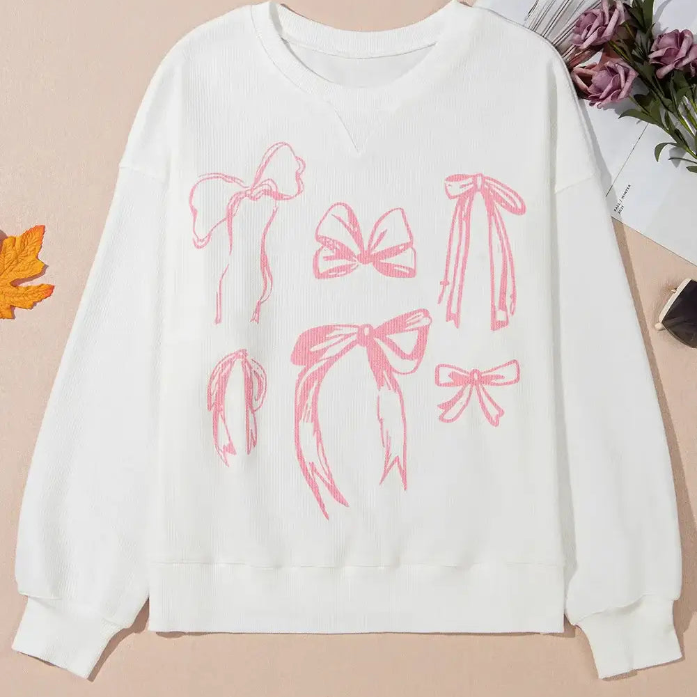 Softly Tied Crewneck featuring pink bowknot pattern on a white corded long sleeve top.
