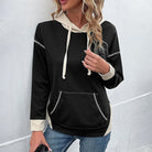 Stylish woman wearing a MODERN EDGE HOODIE in black with contrast details, perfect for casual looks and comfortable wear.
