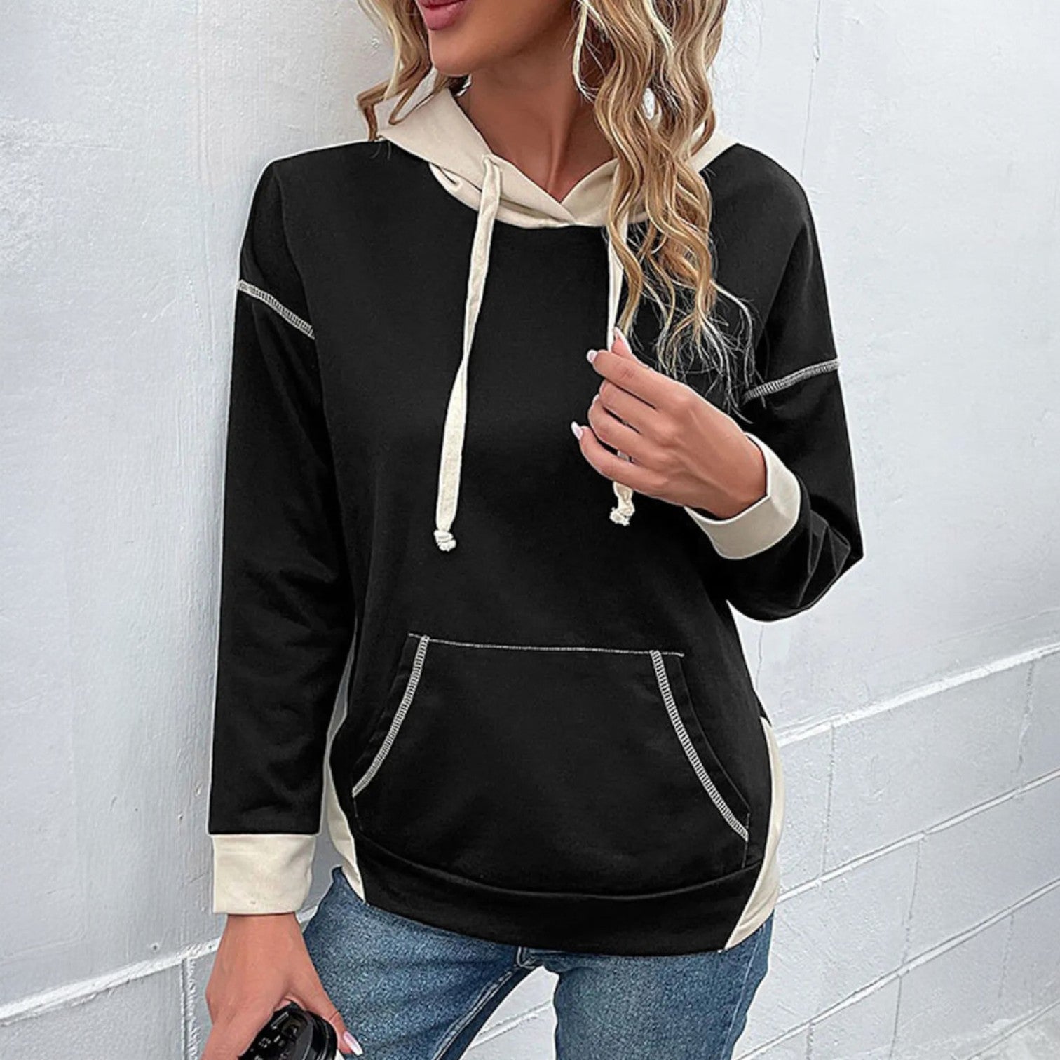 Stylish woman wearing a MODERN EDGE HOODIE in black with contrast details, perfect for casual looks and comfortable wear.