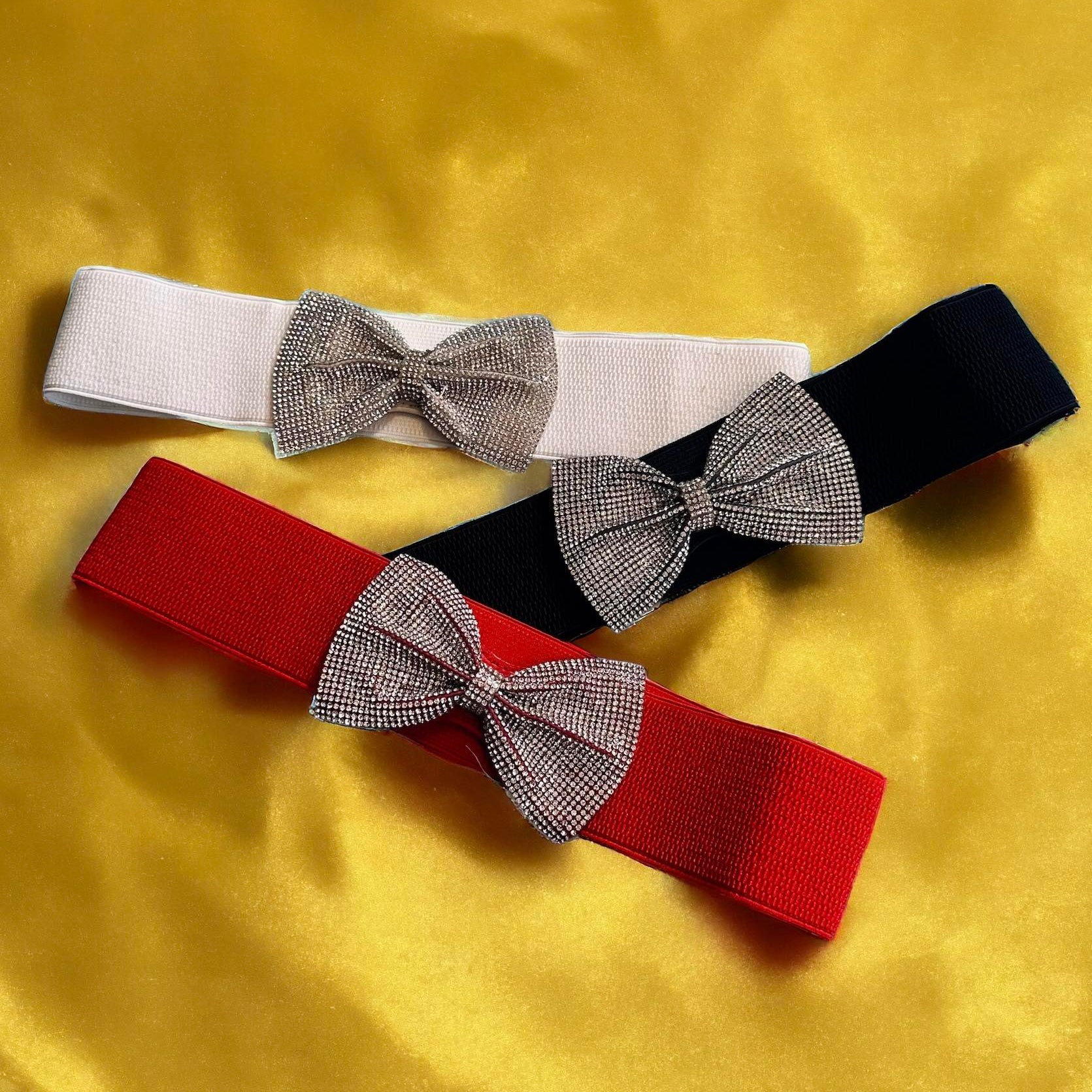 Elastic belts in red, white, and black with rhinestone bows, perfect for adding sparkle to your outfit.