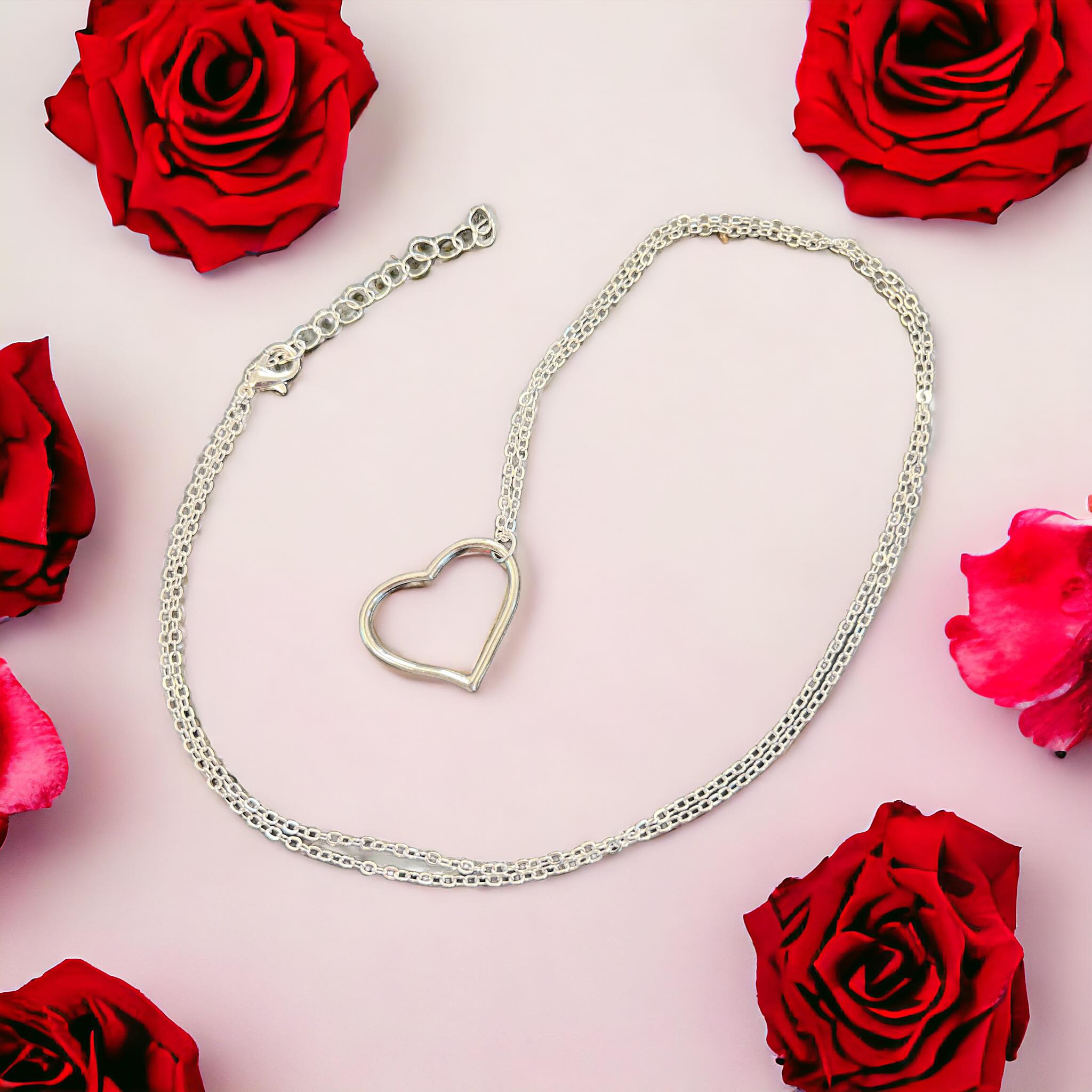 Silver Open Heart Necklace surrounded by red roses, perfect for expressing love and affection.