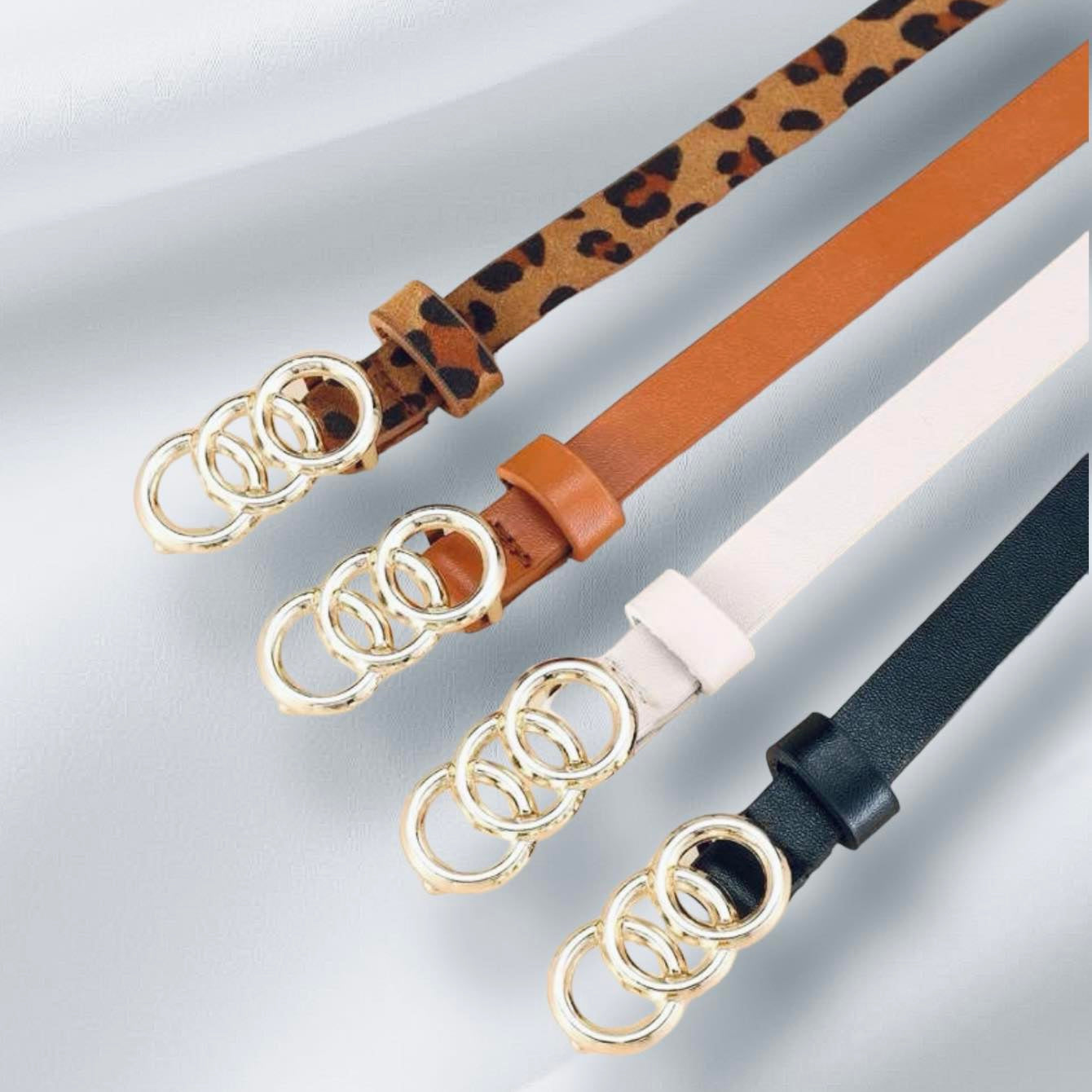Circles of Life Belts in leopard, tan, white, and black with gold tone overlapping circles.