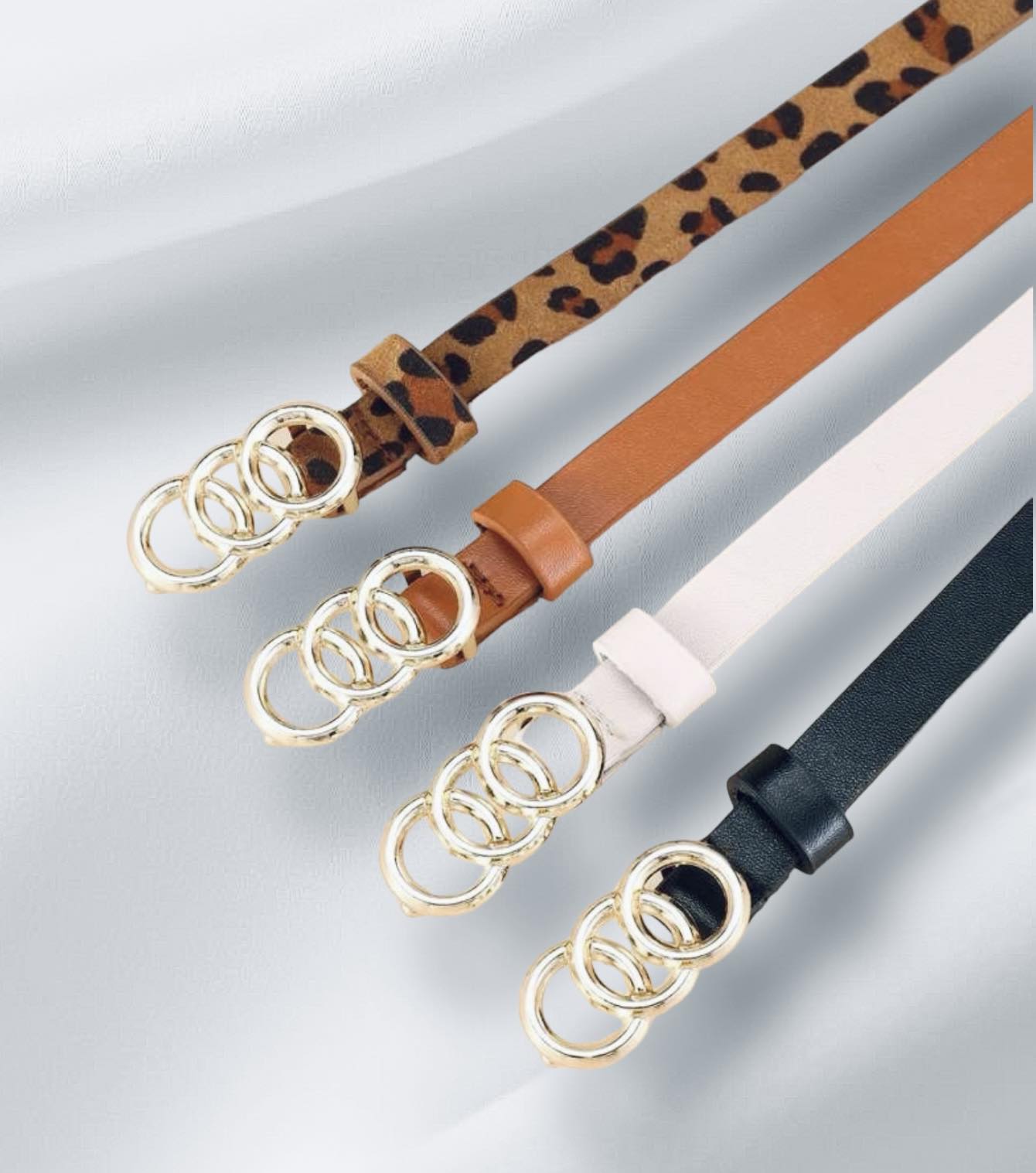 Circles of Life Belts in leopard, tan, white, and black with gold tone overlapping circles.