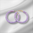 Violet sparkle hoop earrings adorned with shimmering purple glitter, perfect for adding elegance to any outfit.