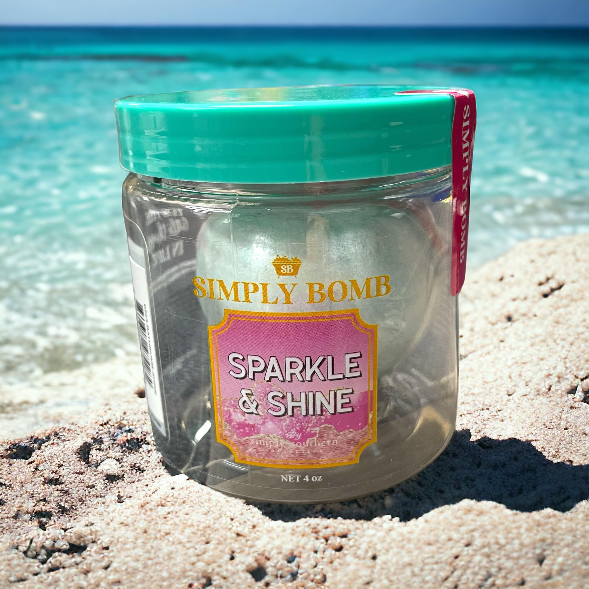 Simply Southern Bath Bombs Sparkle & Shine jar on a sandy beach, ideal for relaxation and gift-giving.