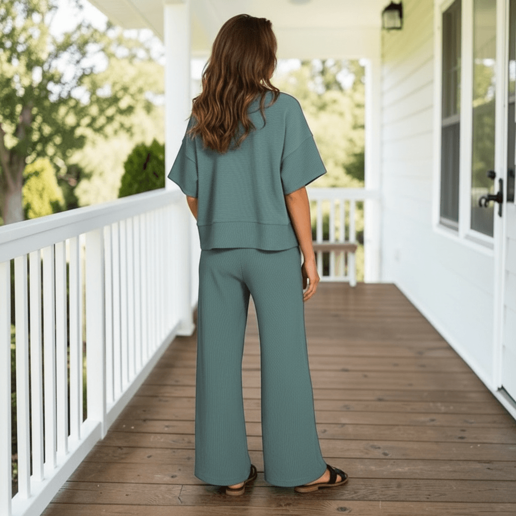 QUIET MOMENTS PANTS SET (ash jade) model wearing back view on a porch with wooden flooring.