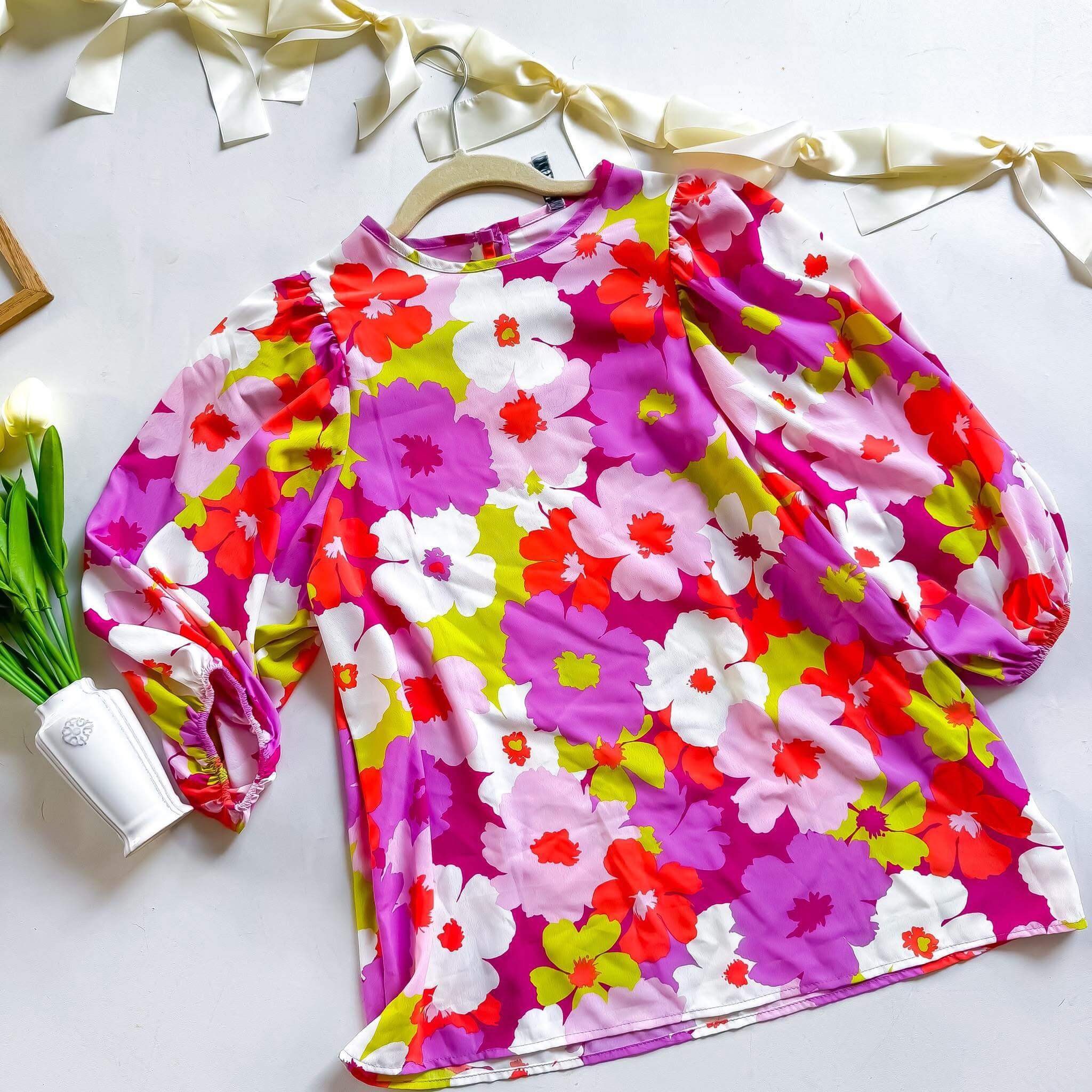 Vibrant floral puff sleeve blouse by 2 Hearts featuring fuchsia, red, green, and white blooms, made in the USA.