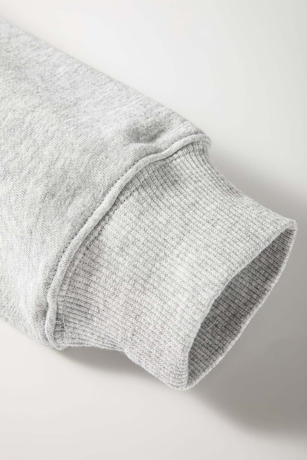 Close-up of the cuff detail on a grey Christmas sweatshirt, soft fabric perfect for festive occasions.