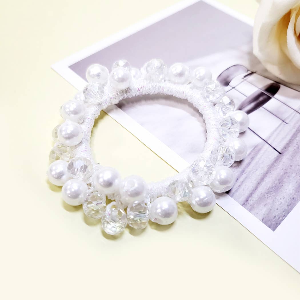 Charmed Twists hair tie with glass beads and faux pearls on a pastel background, stylish and elegant for all hair types.