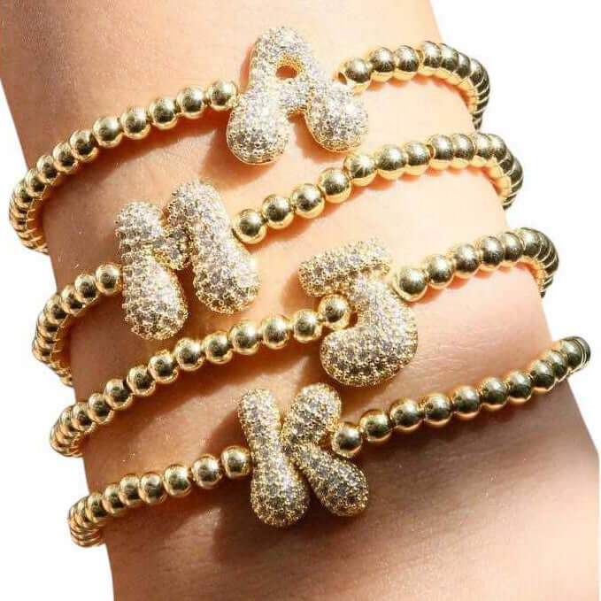 Gold-tone bubble bling bracelets featuring rhinestone letters A, M, J, K for personalized glam and comfort.
