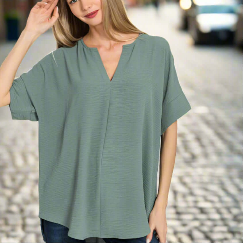 Woman wearing a Soft Breeze Top in ash jade color, showcasing its stylish and breathable design.