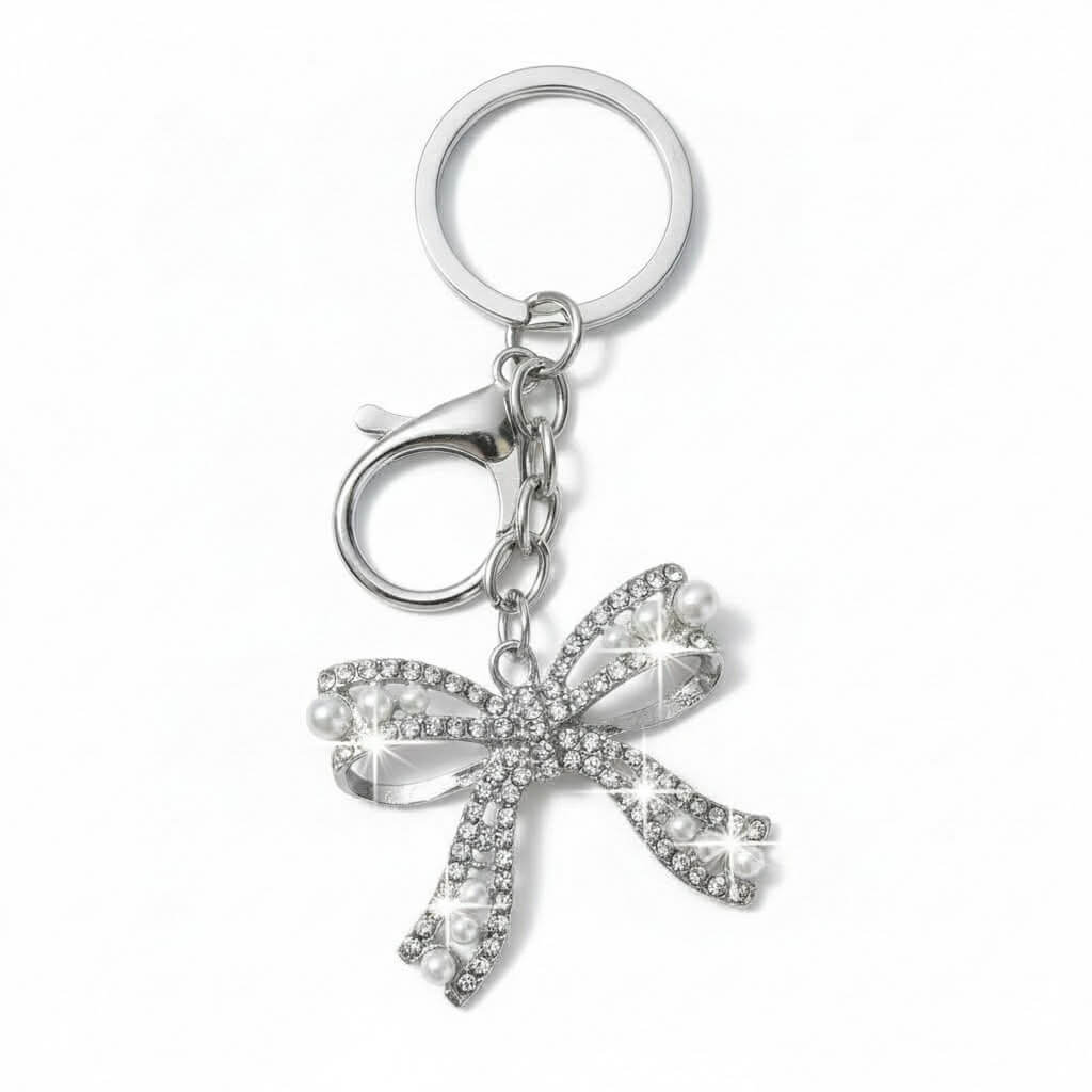 ENCHANTED BOW Bag Charm / Keychain in silver with rhinestones and faux pearls, adding sparkle and charm to accessories.