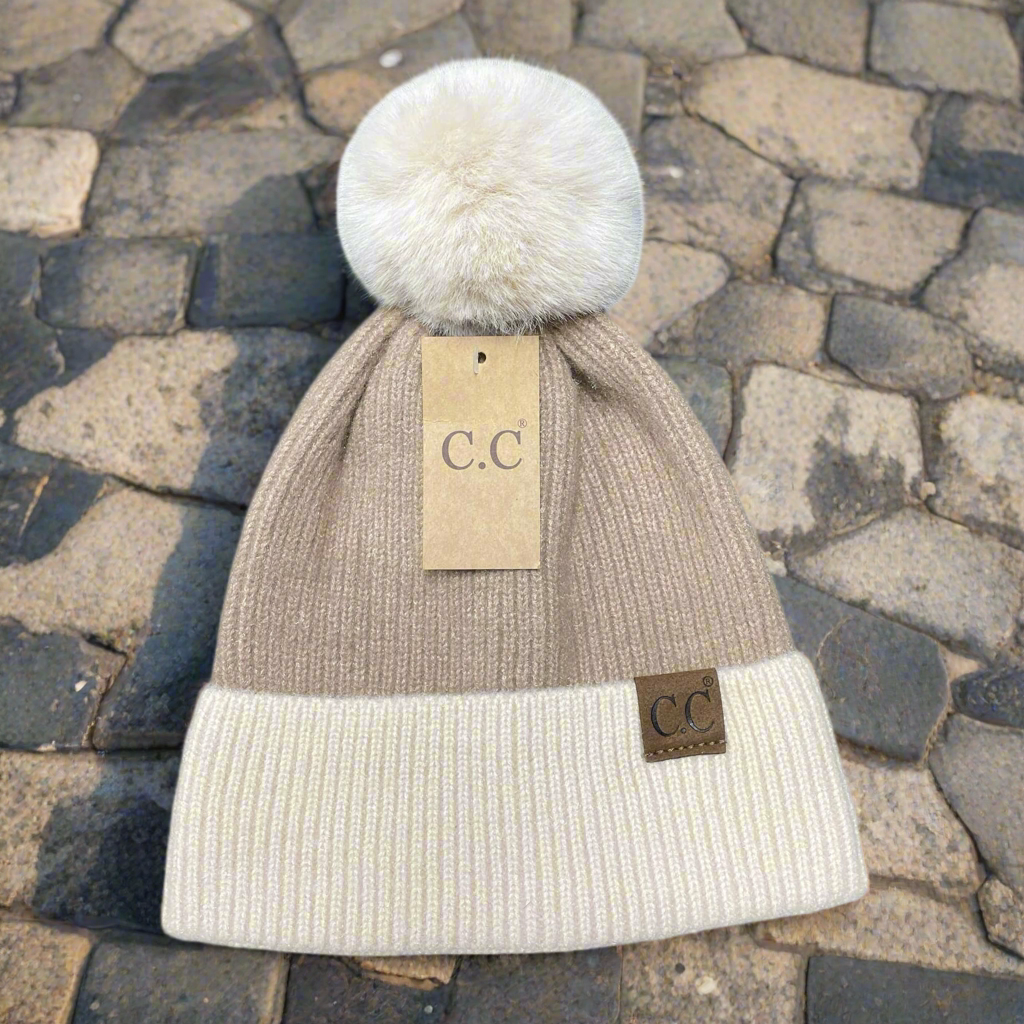 Tan beanie with beige cuff and fur pom pom by C.C., perfect for stylish winter warmth.