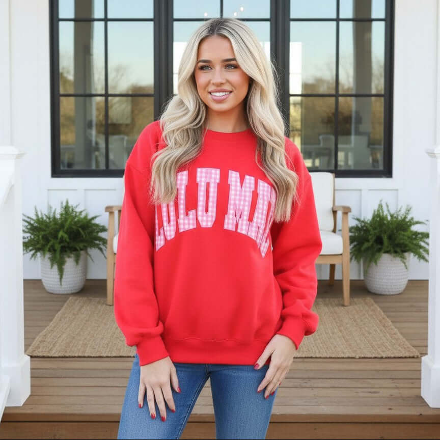 LULU MAC RED W/PINK GINGHAM CREWNECK worn by a model, showcasing the vibrant red sweatshirt with pink gingham graphic.