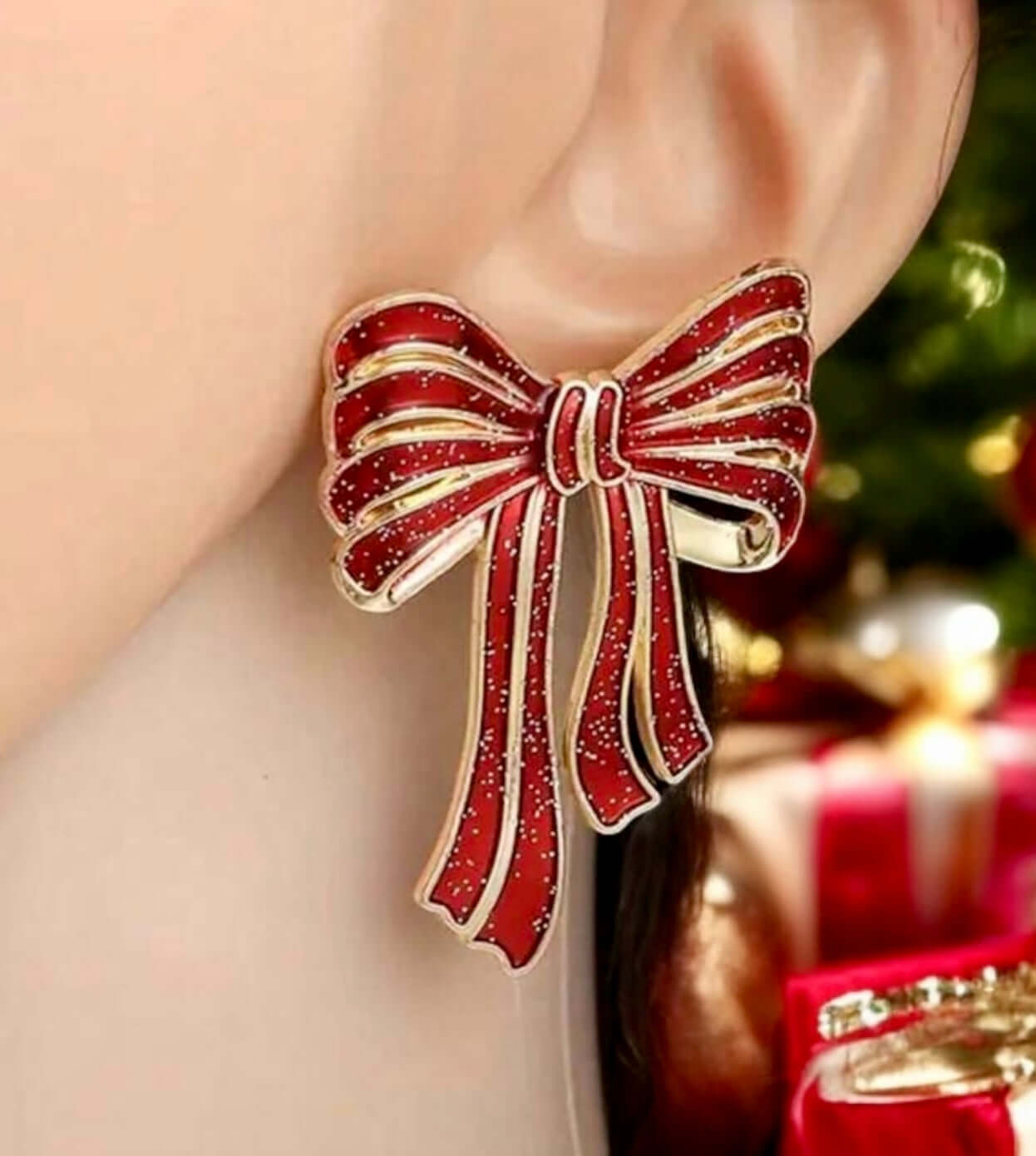 Close-up of red and gold bow earrings, perfect for festive holiday wear, measuring 2x1.4 inches.
