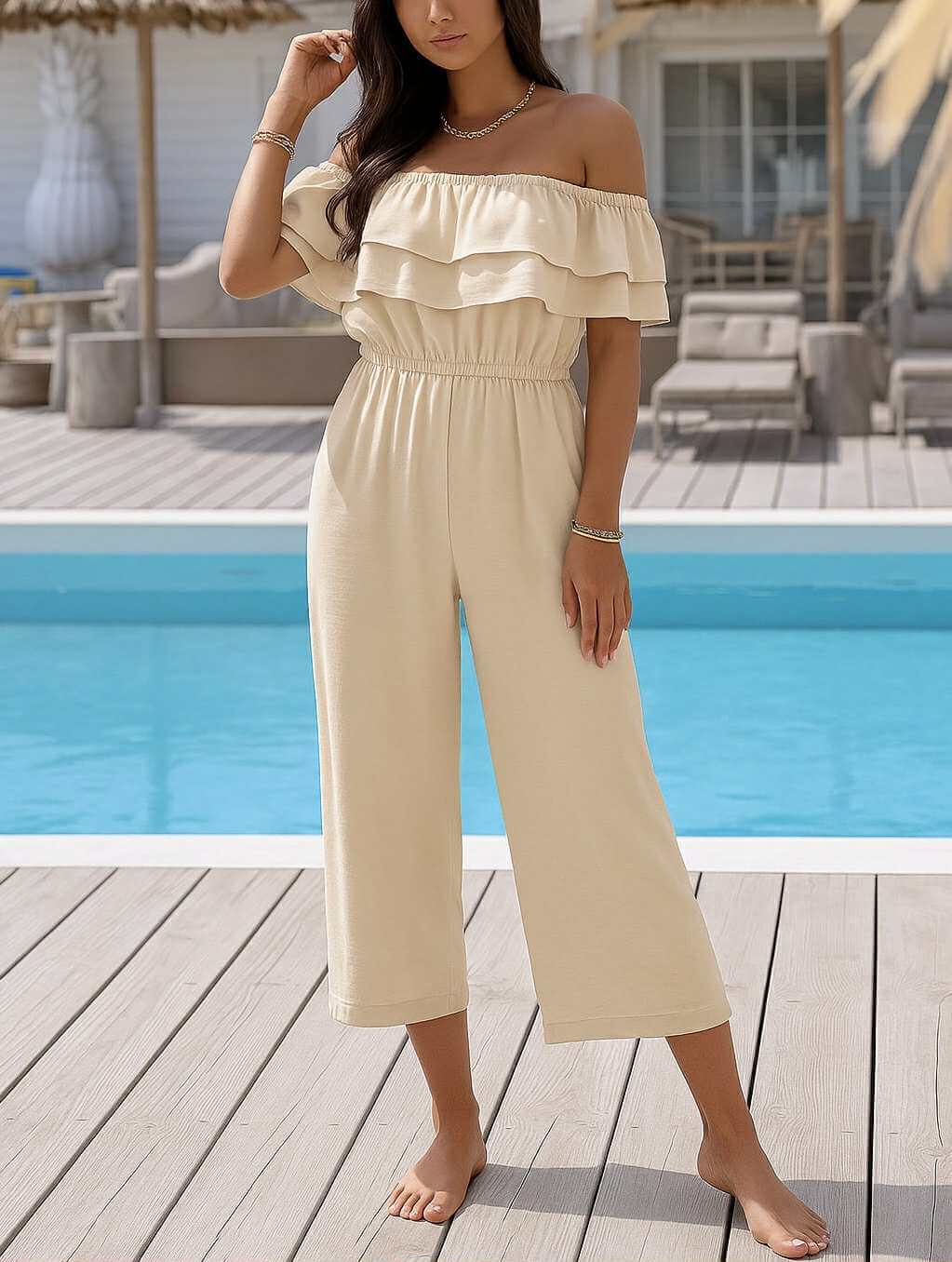 Model wearing a cream off-shoulder Carefree Coast Jumpsuit by Sweet Lovely by Jen near a pool.