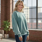 DOWNTOWN DRIFT CREW NECK model wearing a mineral wash pullover in a bright urban setting.