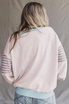 Model wearing the back view of the EASYGOING ERA CREW (taffy) with striped patchwork sleeves.