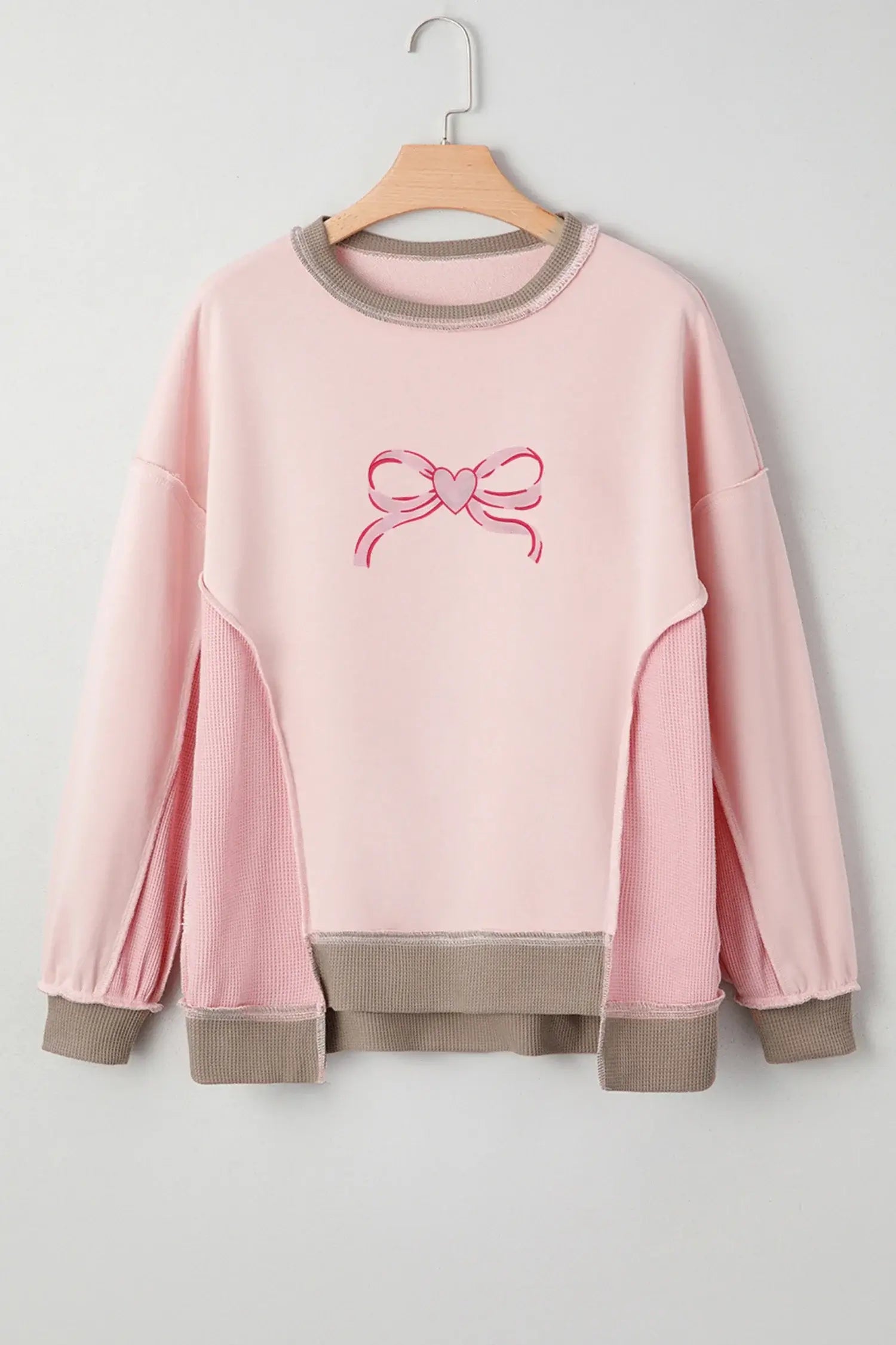 FROM THE HEART PULLOVER featuring heart bow embroidery in soft light pink with trendy color block details.