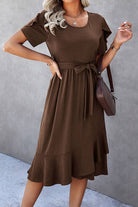 Model wearing HOT CHOCOLATE MIDI DRESS with petal sleeves and ruffle trim, styled with a brown handbag.