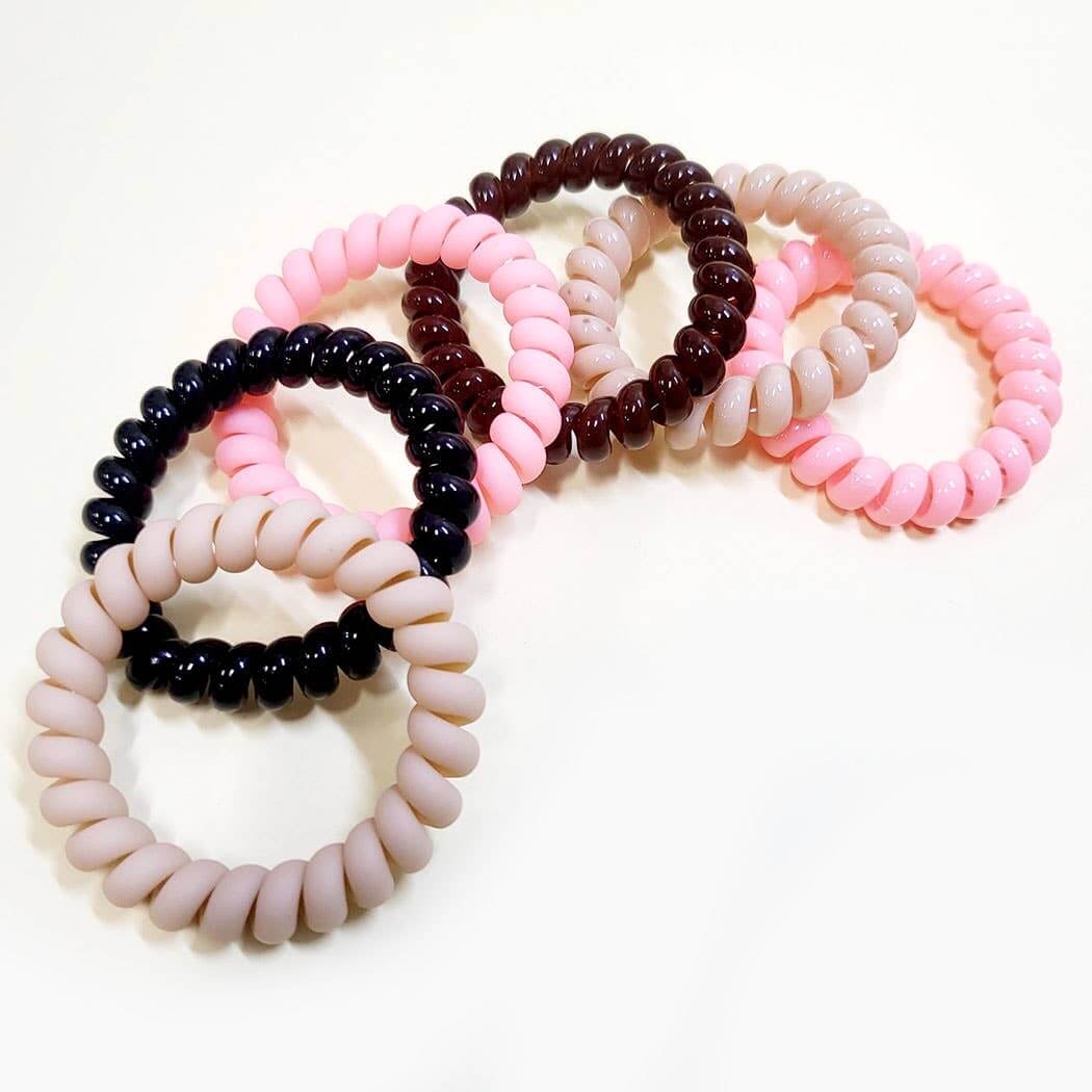 Twist & Tell Hair Tie Set featuring 6 assorted coil bands in neutral and pastel tones.
