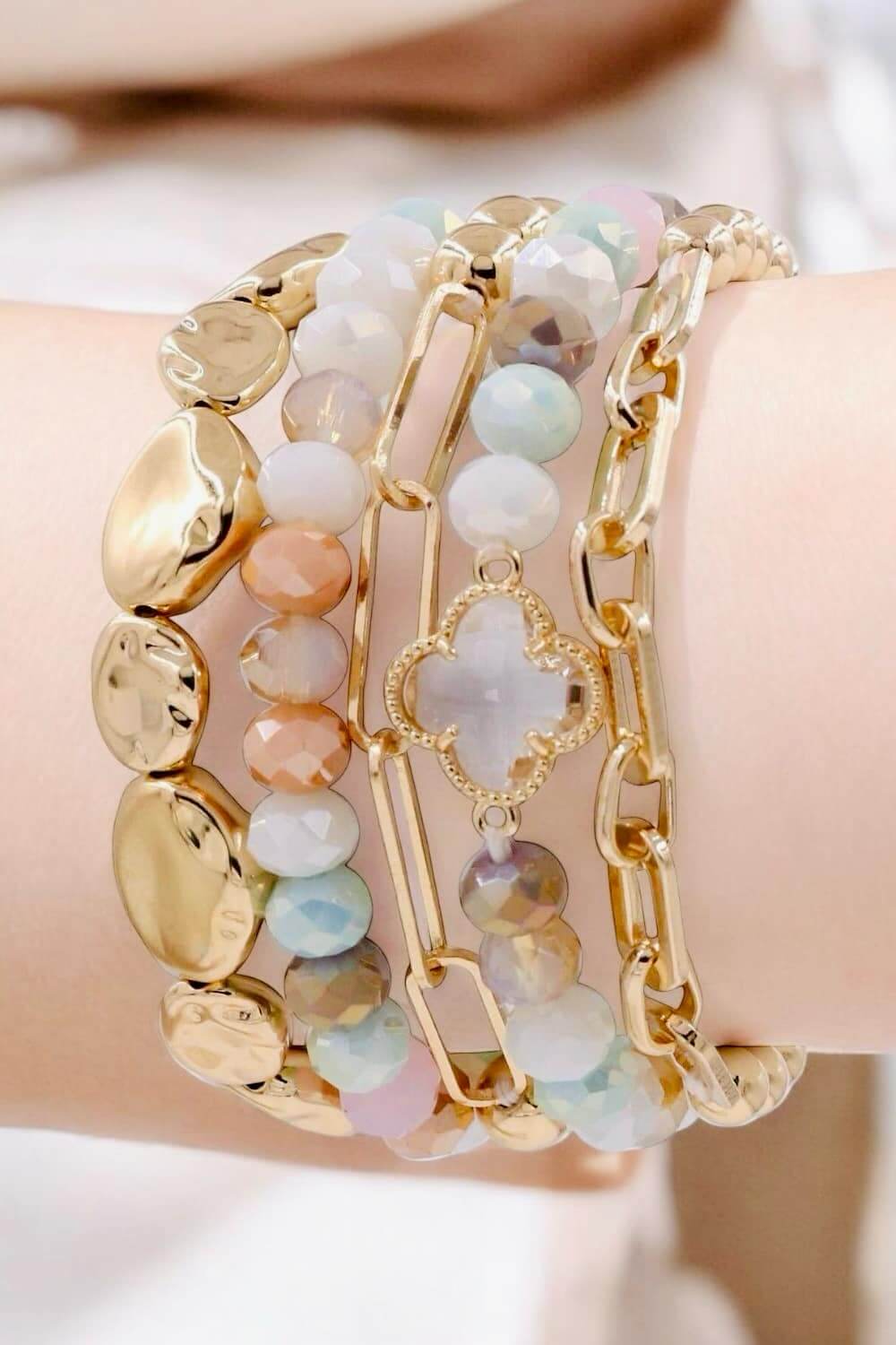 Serene Bracelet Set by Nine Jewelry featuring pastel colors and gold-toned quatrefoil stretch bracelets.