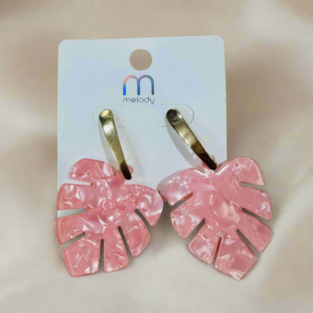 Pink monstera leaf earrings with gold-tone stem posts, perfect for a tropical look.