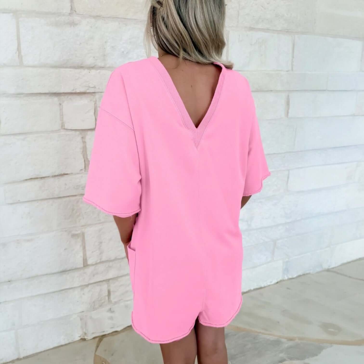 Back view of the CASUAL ESCAPE ROMPER in pink, showcasing its relaxed fit and V-neck design.