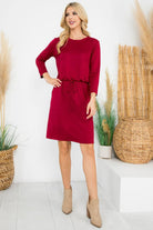Model wearing a stylish Wine and Dine Dress in burgundy with 3/4 sleeves and a cinch waist, perfect for any occasion.