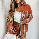 Model wearing HARVEST HAVEN JACKET with rust colorblock plaid pattern, styled with a white top and brown shorts.