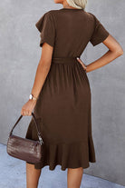 Rear view of a belted HOT CHOCOLATE MIDI DRESS showcasing petal sleeves and ruffle trim in a cocoa color.