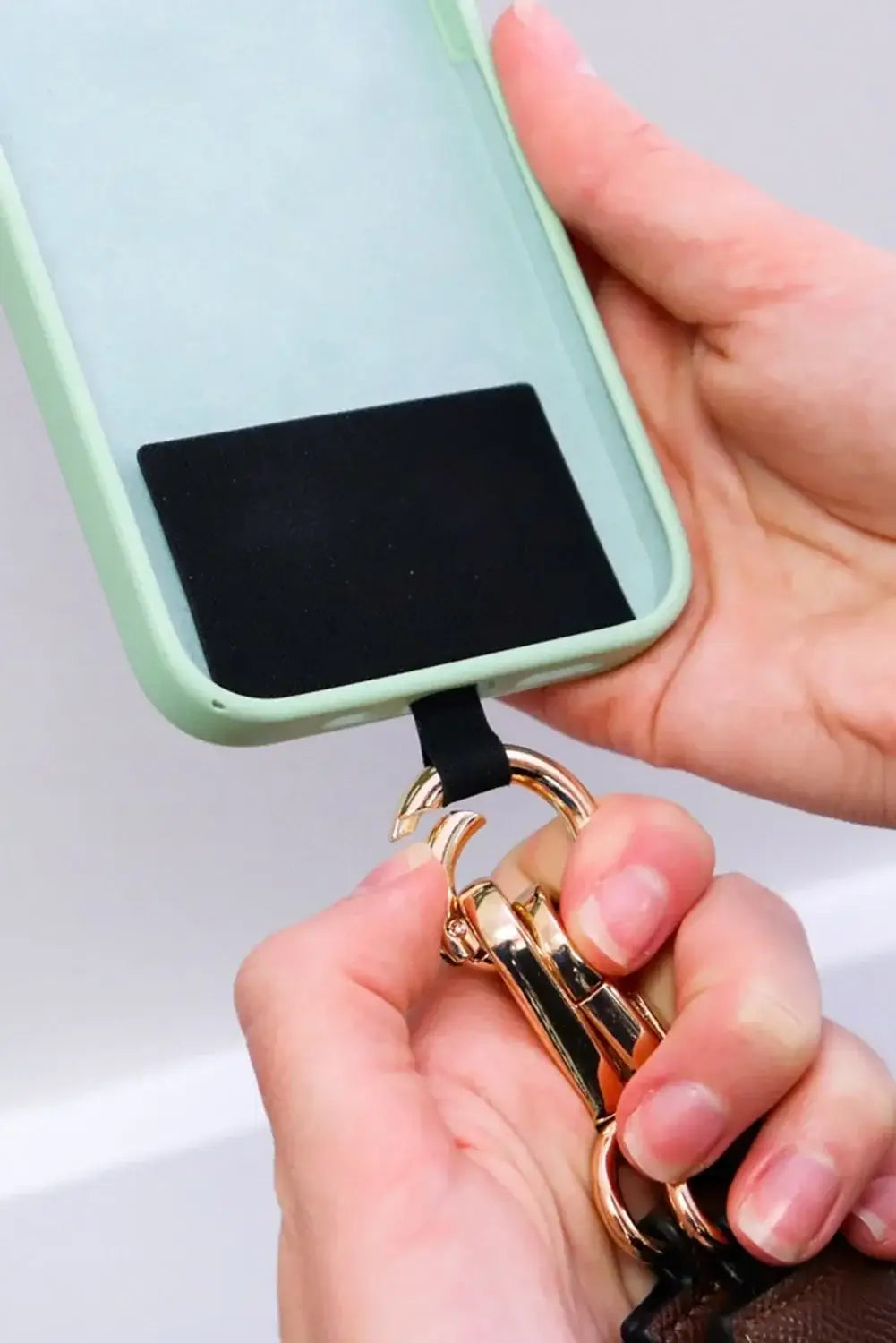 Hands Free Harmony Crossbody shown with a phone being attached to the stylish strap for convenient hands-free use.
